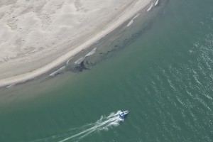 france, Bouches-du-Rhône (13), parc naturel régional de Camargue, Salin de Giraud, embouchure du Rhône, plage d'Arles ou de Piémanson, bateau à moteur (vue aérienne)